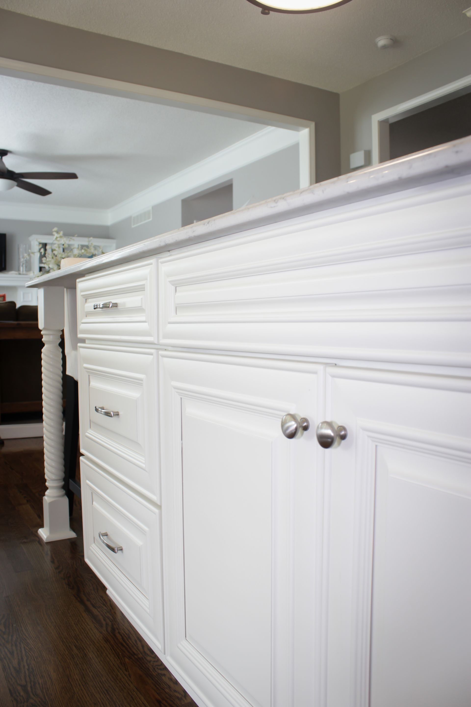 White kitchen island with cabinets, drawers, and silver hardware.
