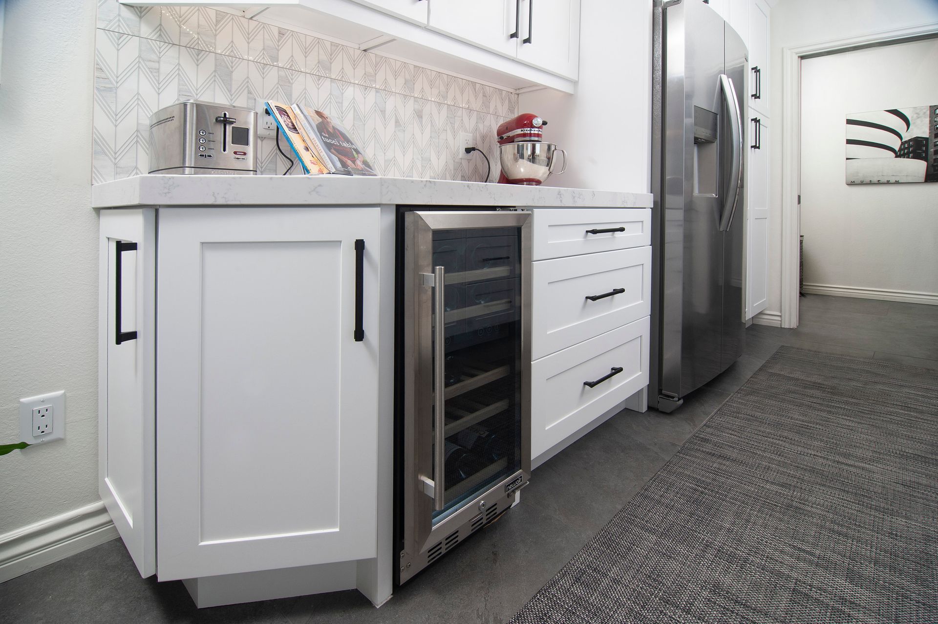 White kitchen cabinets with a built-in wine cooler and refrigerator.