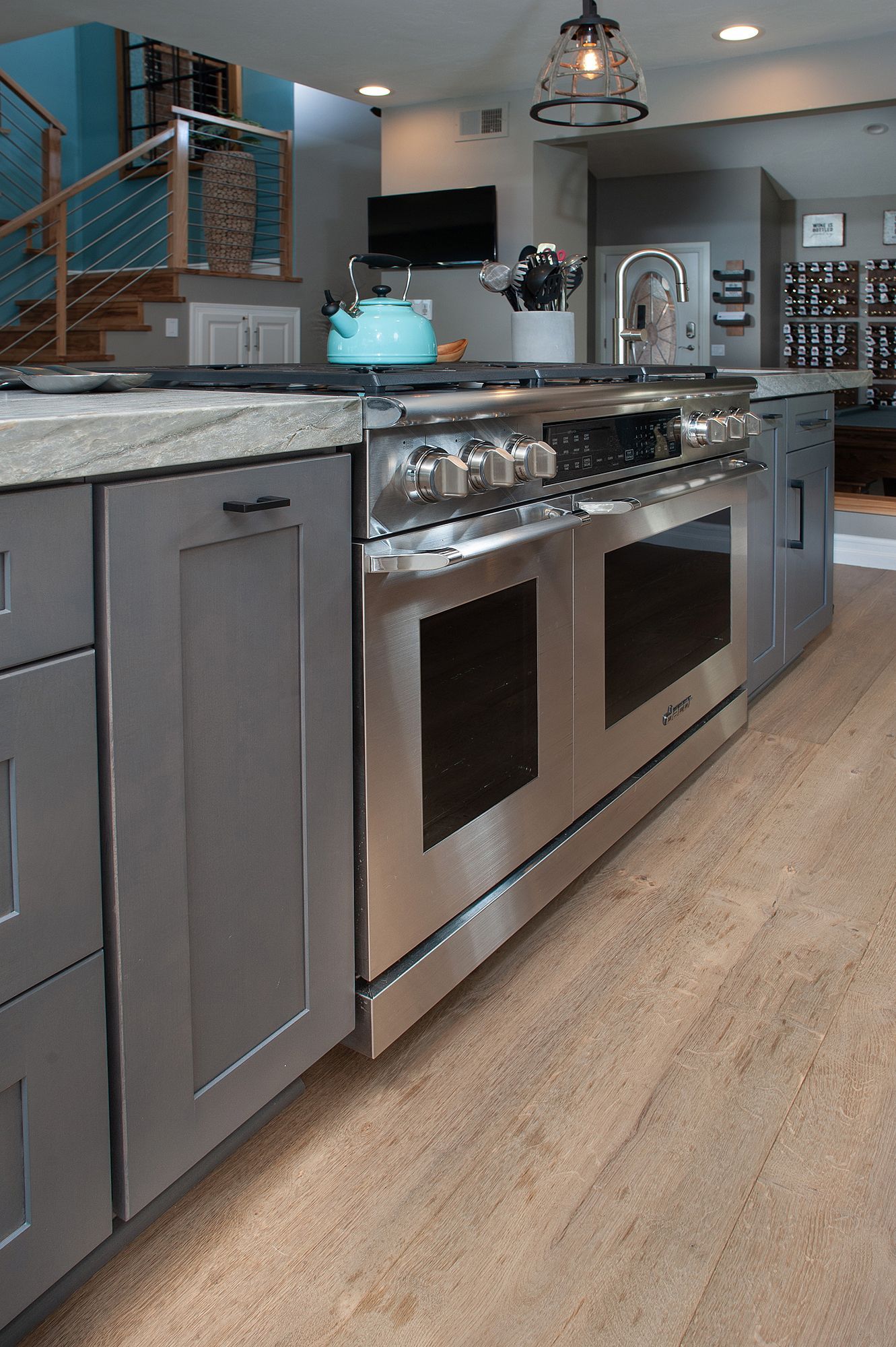 Gray kitchen cabinets with stainless steel oven in modern kitchen.