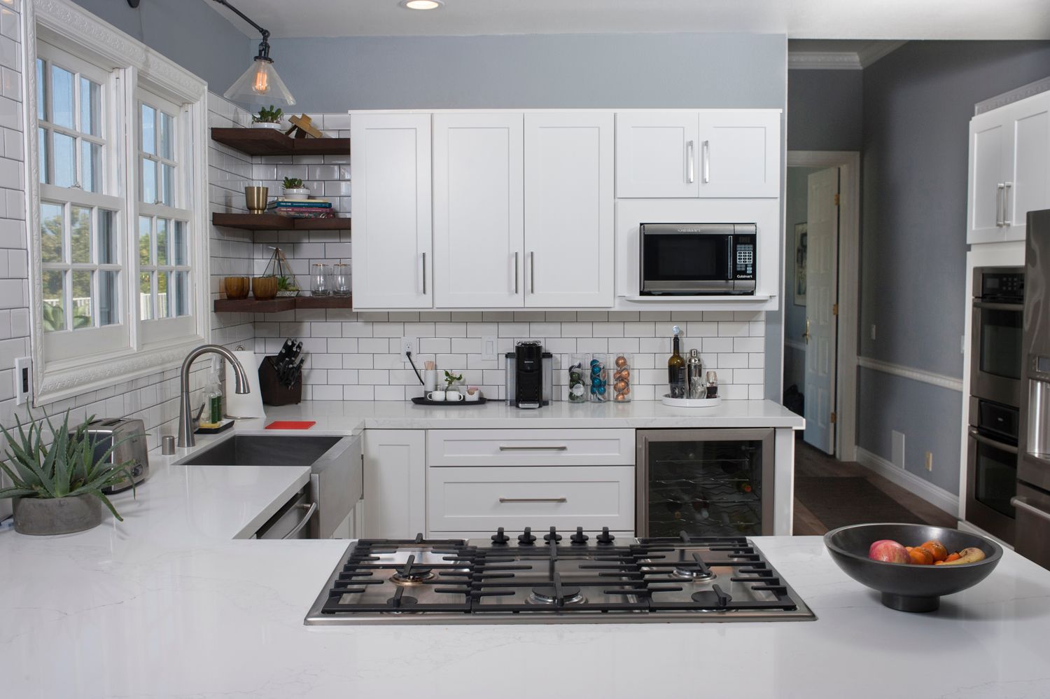 Bright kitchen with white cabinets, subway tile backsplash, and gas stovetop.