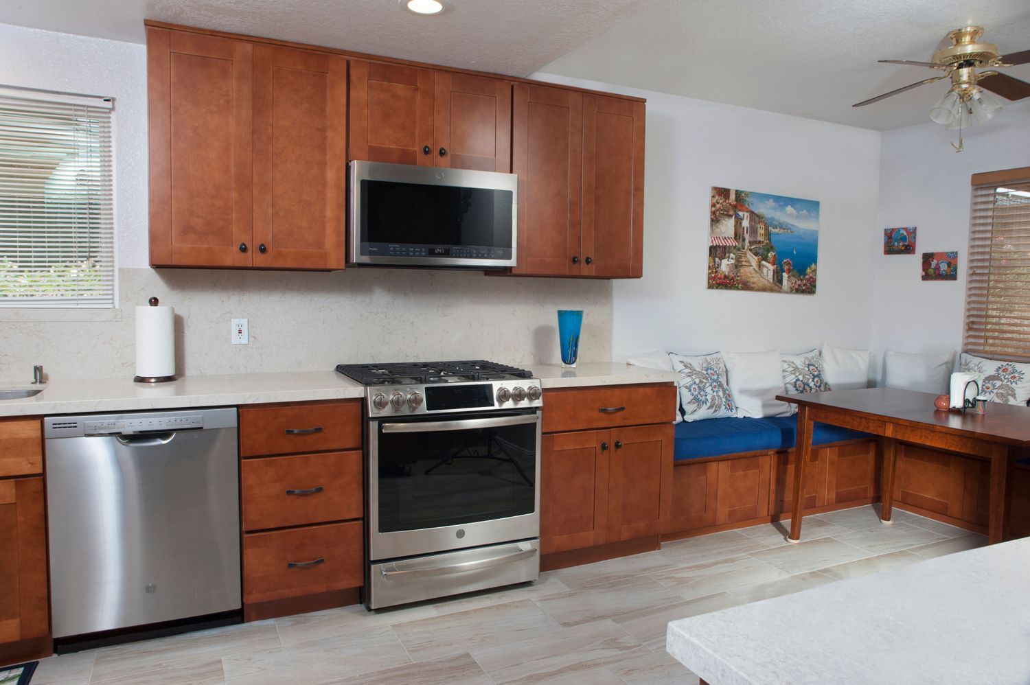 Kitchen with stainless steel appliances, wood cabinets, and a built-in dining nook.