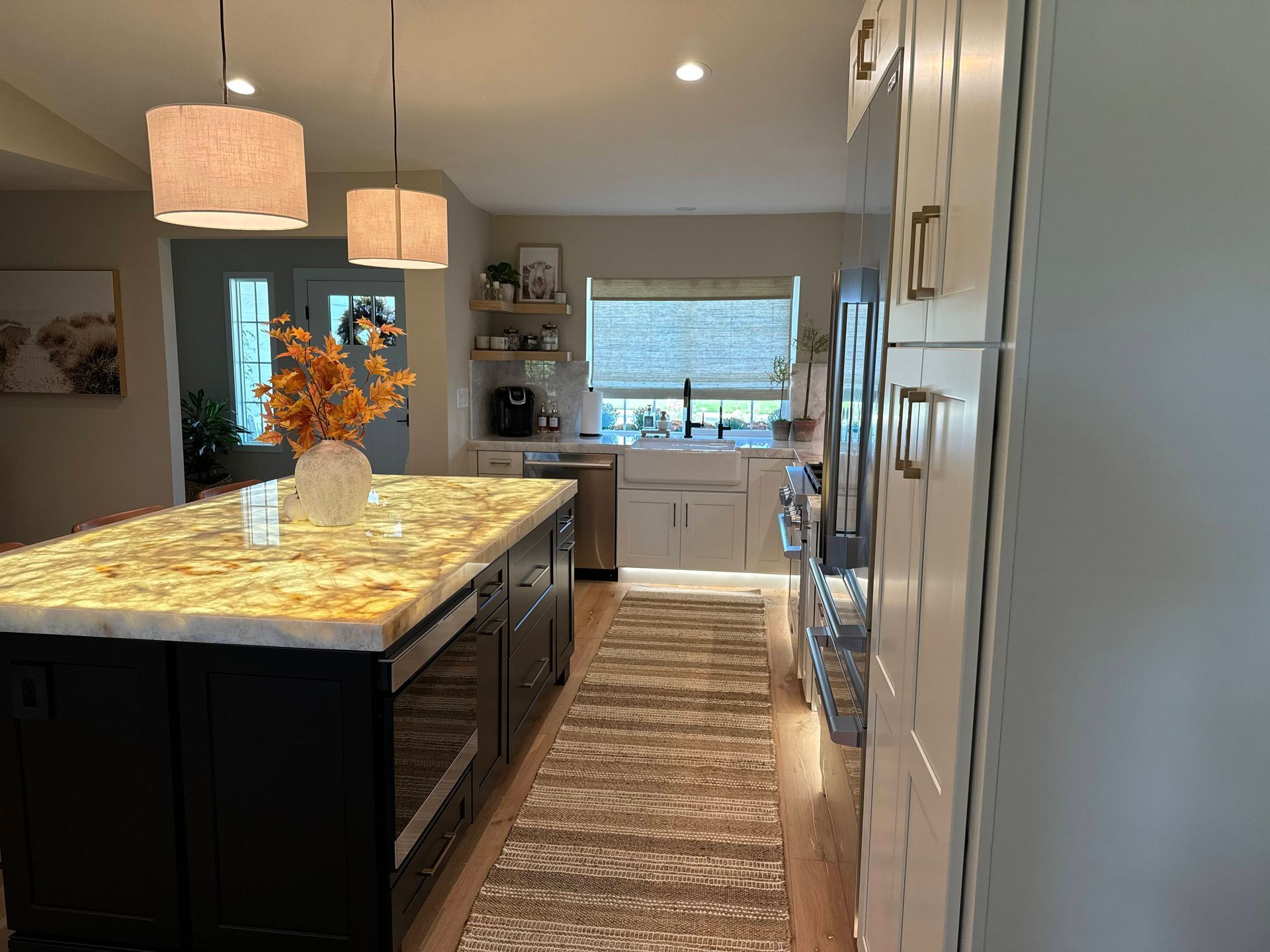 Kitchen with a black island, light countertops, and white cabinets.