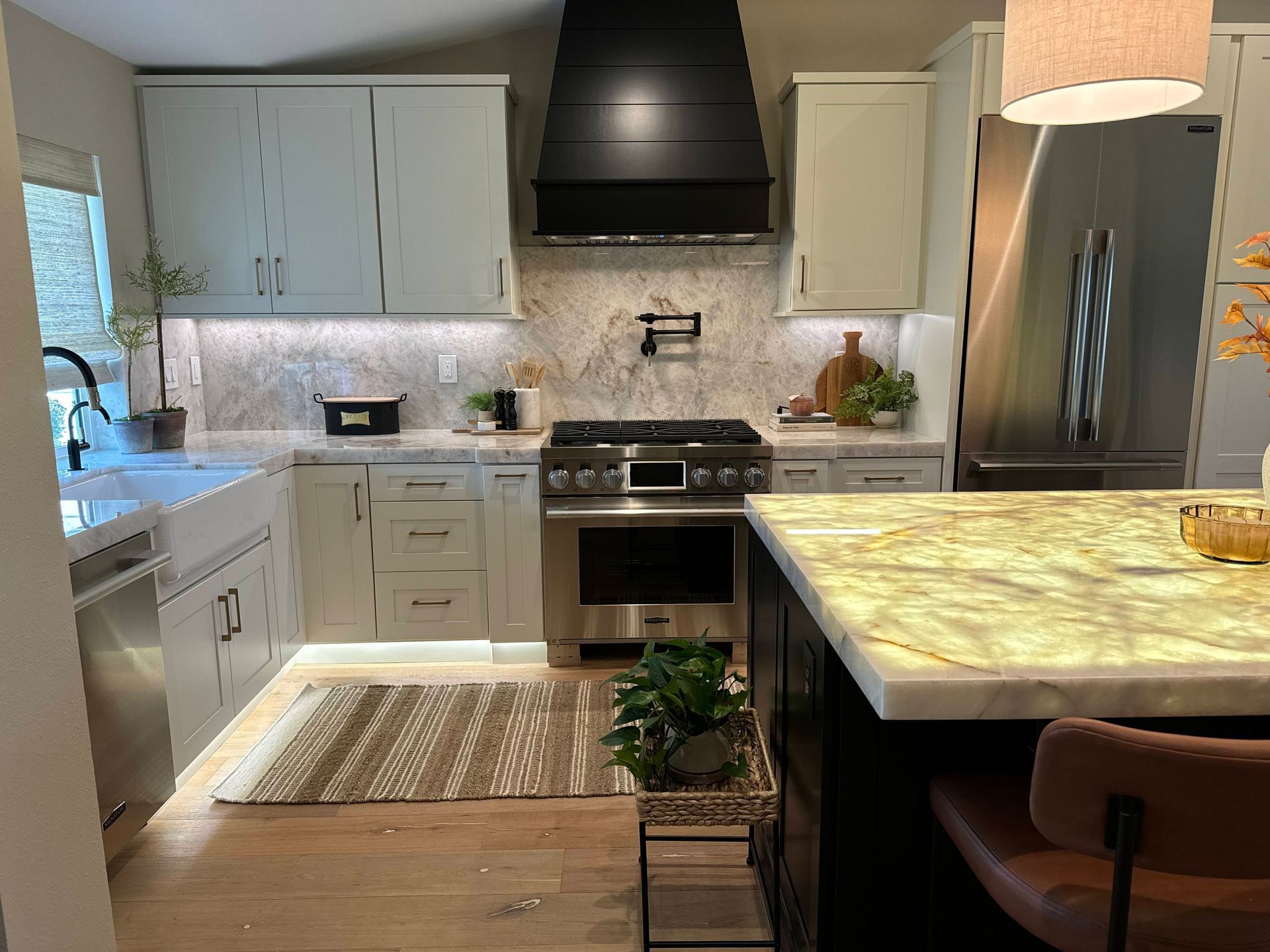 Kitchen with light blue cabinets, stainless steel appliances, and a marble countertop.