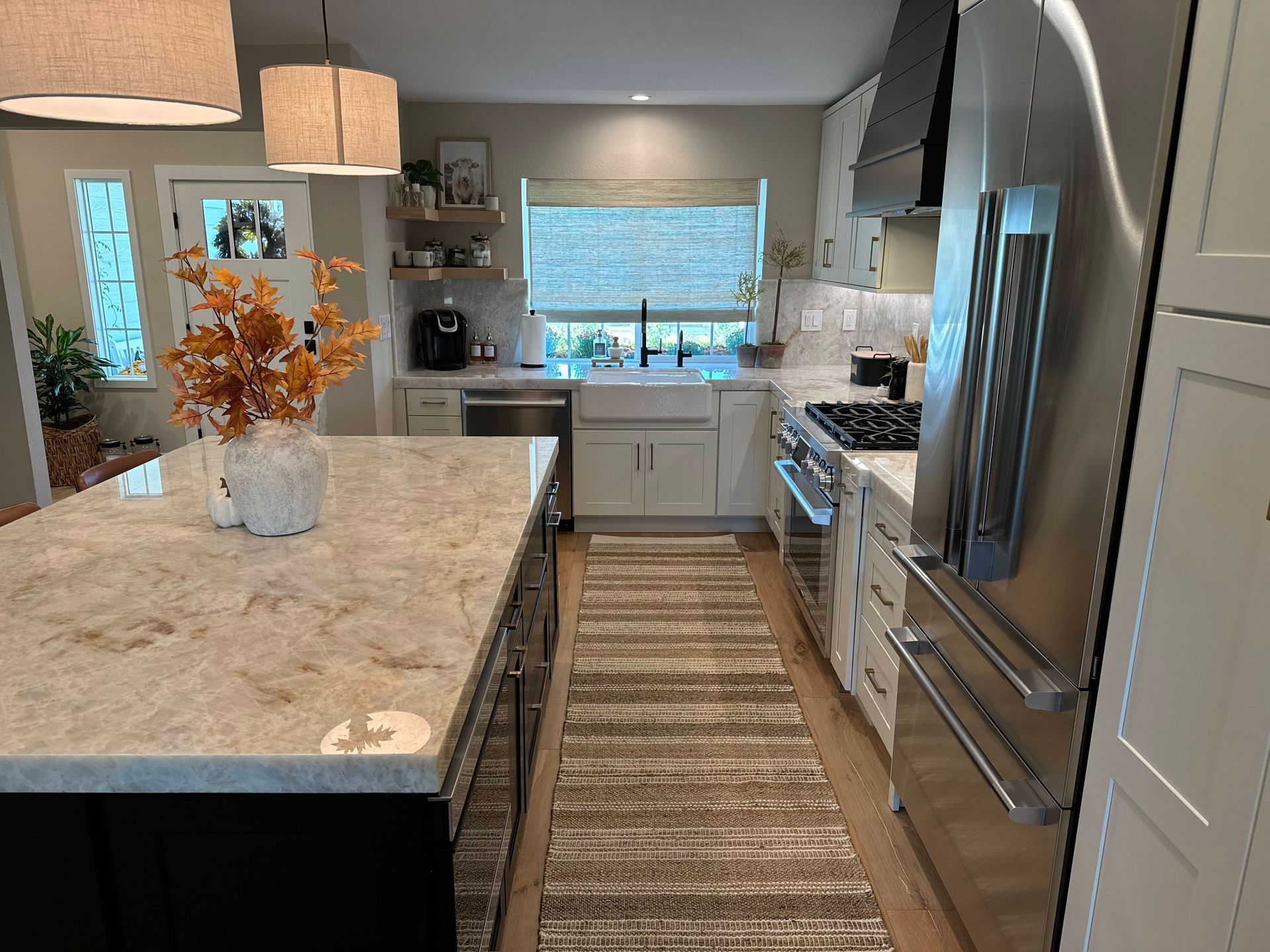 Modern kitchen with island, stainless steel appliances, and white cabinets.