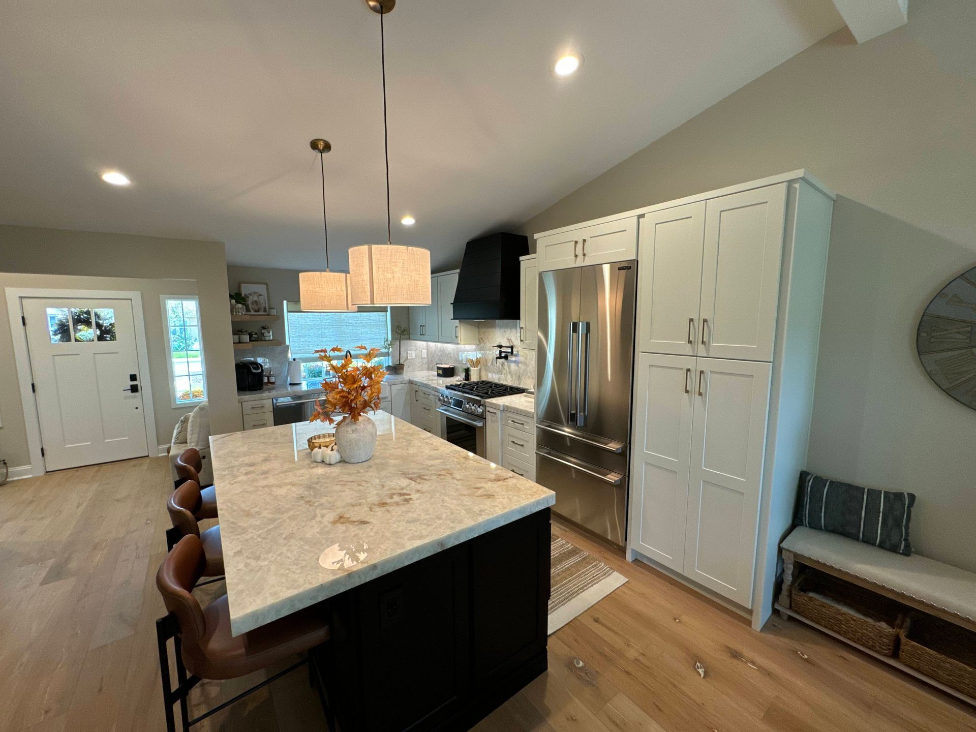 Spacious kitchen with a black island, white cabinets, and stainless steel appliances.