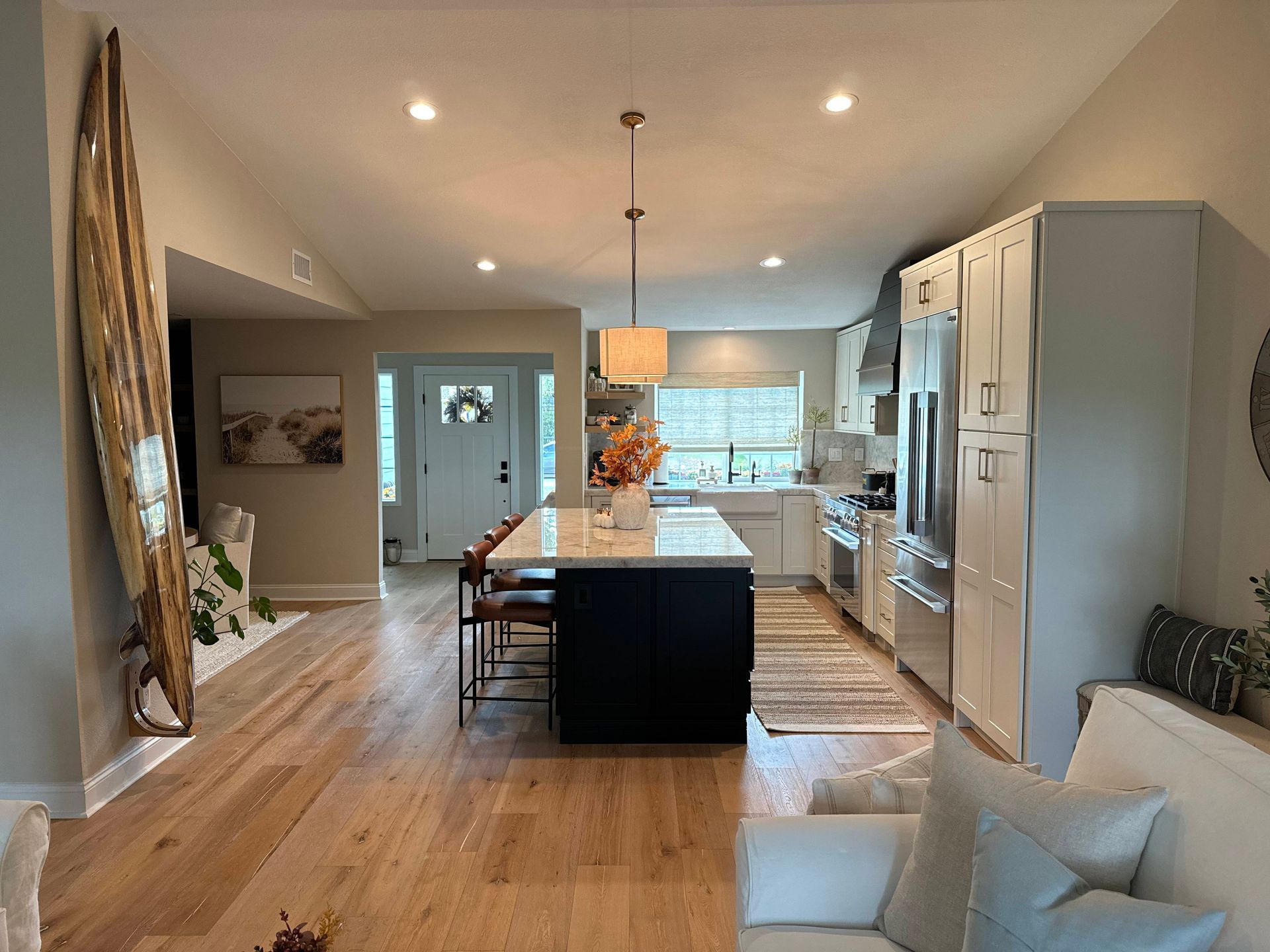 Spacious kitchen with island and stainless steel appliances. Hardwood floors, neutral colors, and natural light.