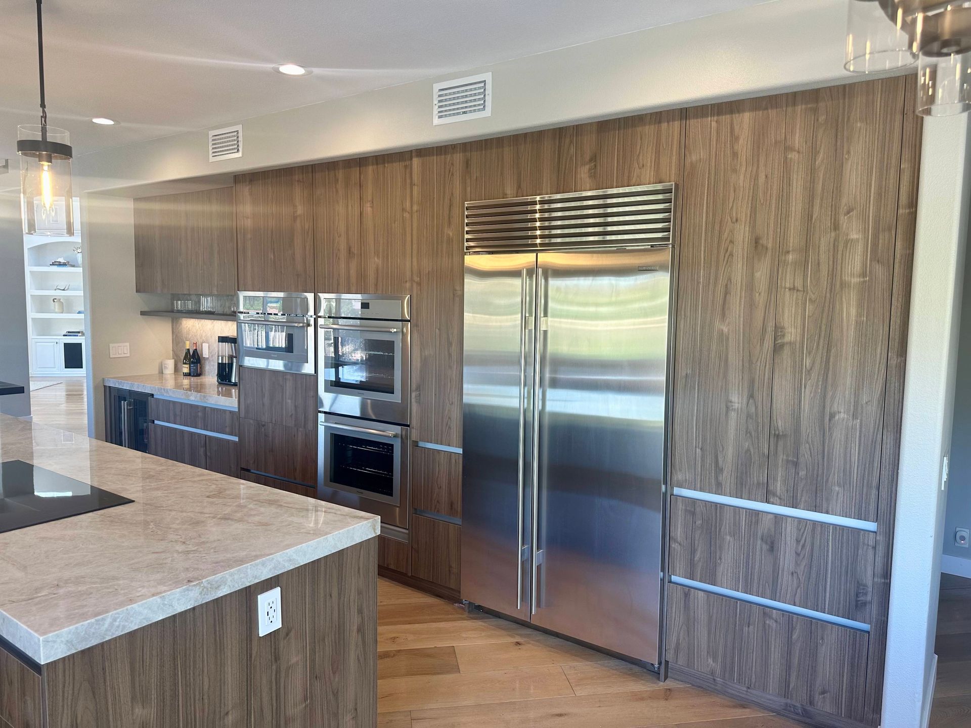 Modern kitchen with wood cabinets, stainless steel appliances, and granite island.