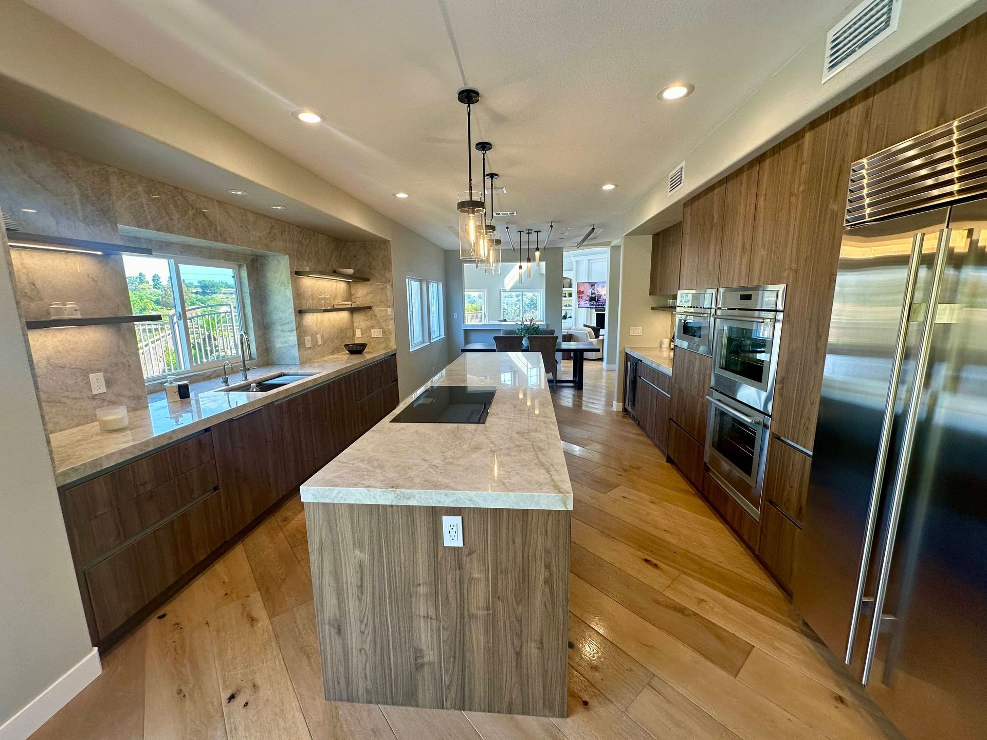 Modern kitchen with wood cabinets, island, and stainless steel appliances.