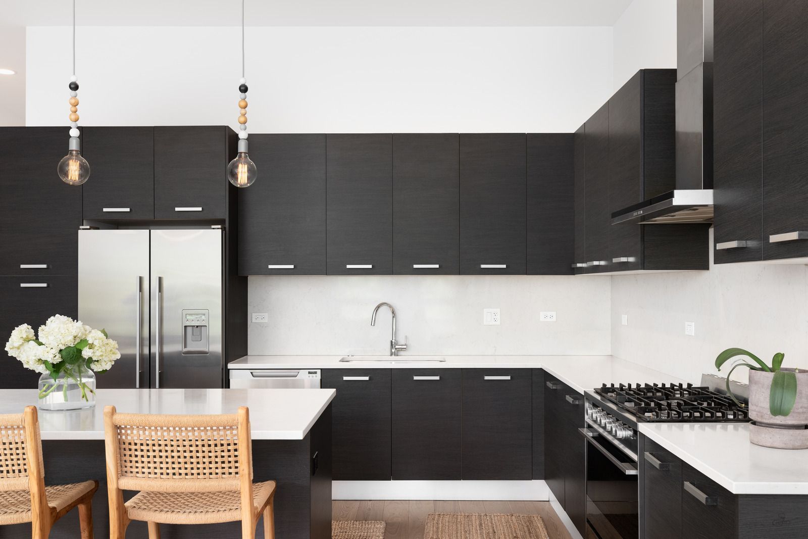 A kitchen with white cabinets , granite counter tops , stainless steel appliances and a stove.