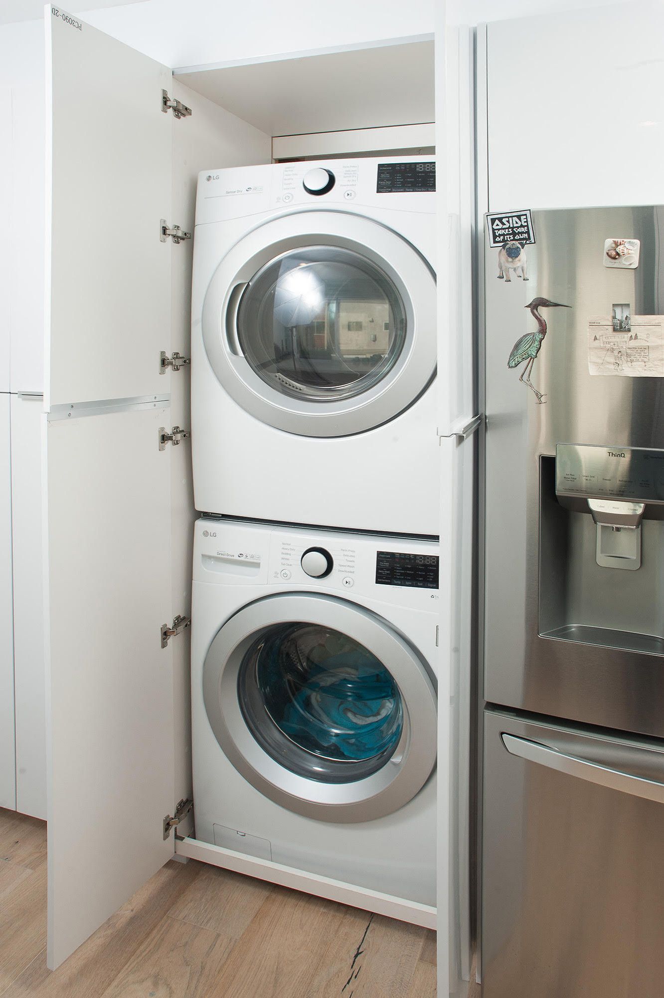 A washer and dryer are stacked on top of each other in a laundry room.