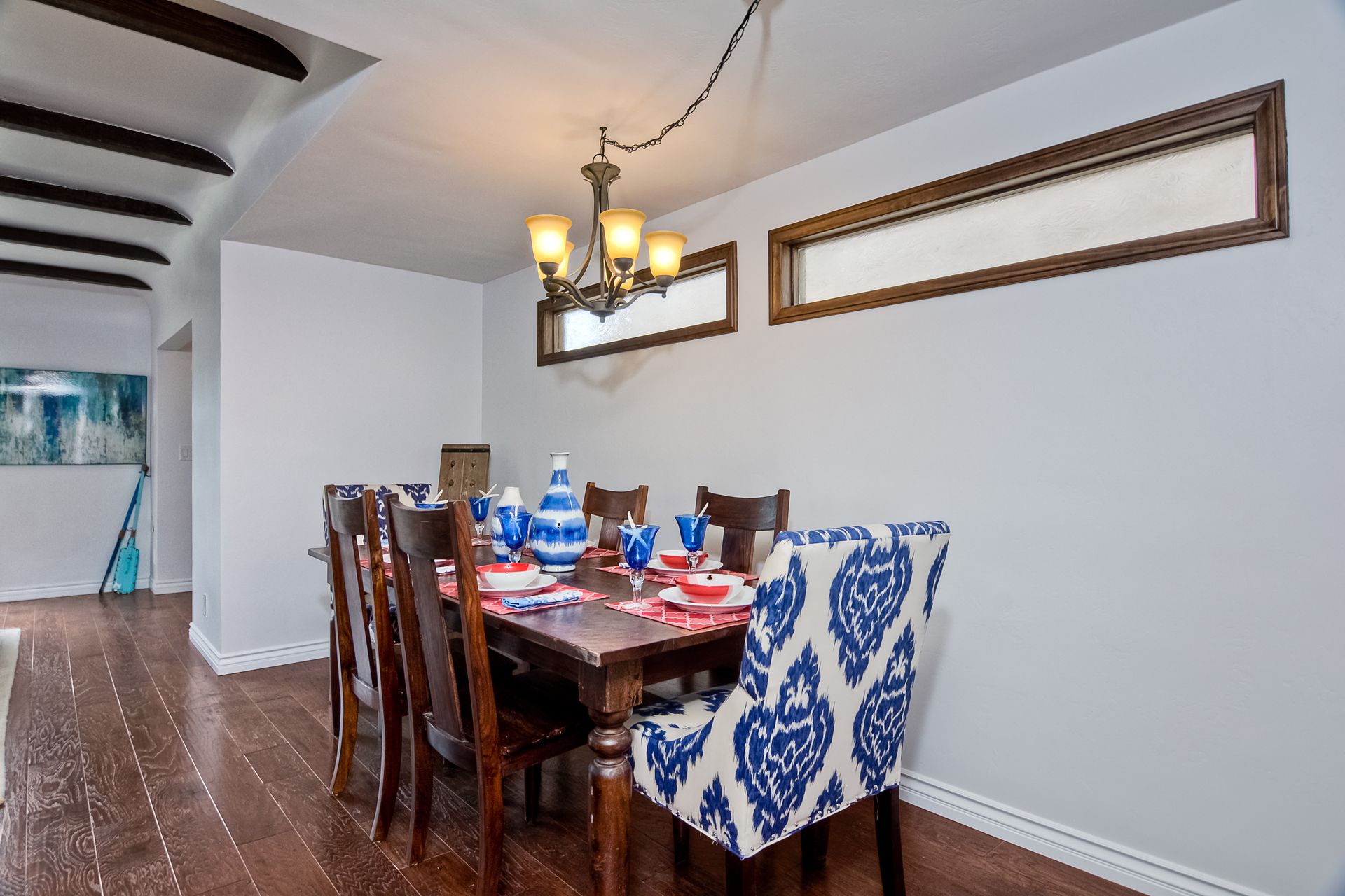 Dining room with a dark wood table, chairs, and a chandelier.