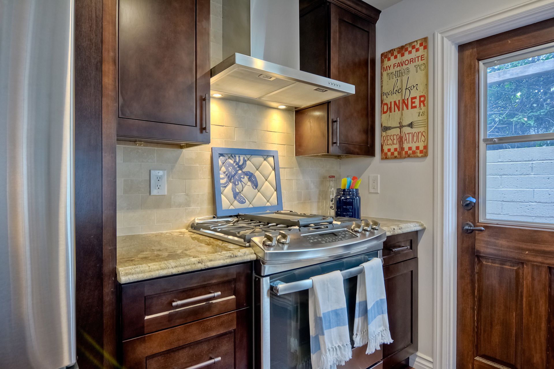 Kitchen with dark wood cabinets, stainless steel stove, and vintage 