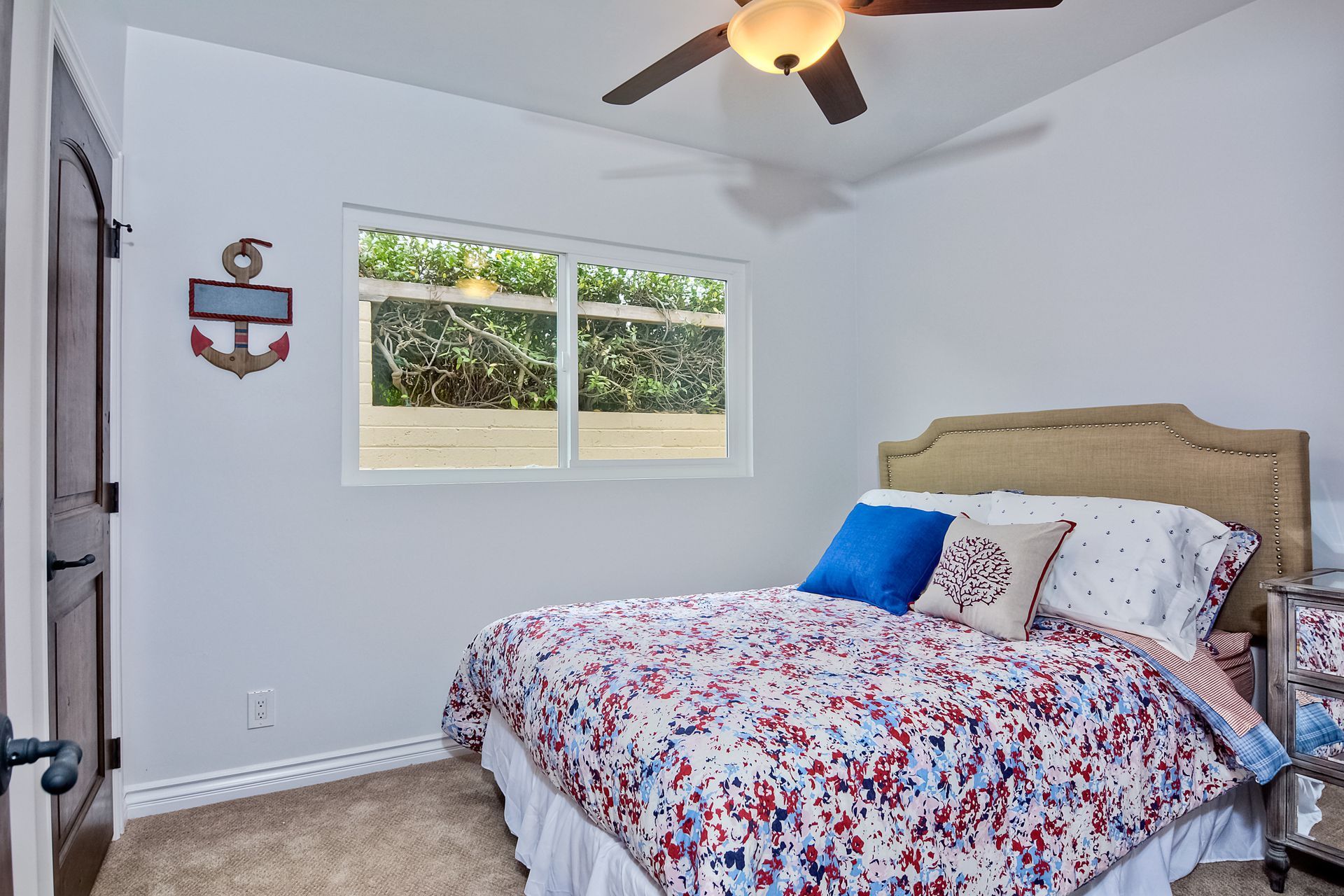 Bedroom with bed, nautical decor, and window.