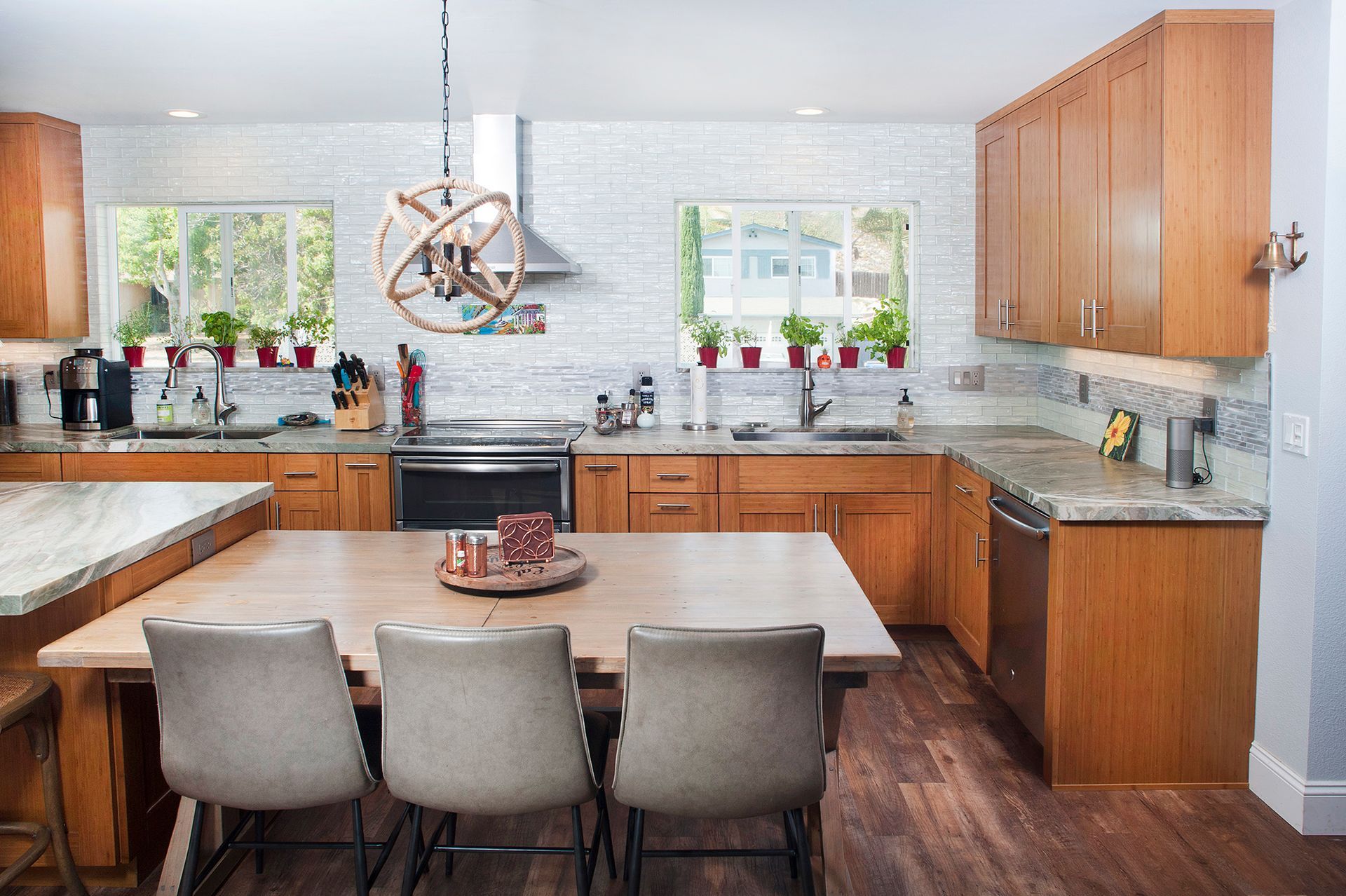 Spacious kitchen with wooden cabinets, island with three chairs, and light-colored brick backsplash.