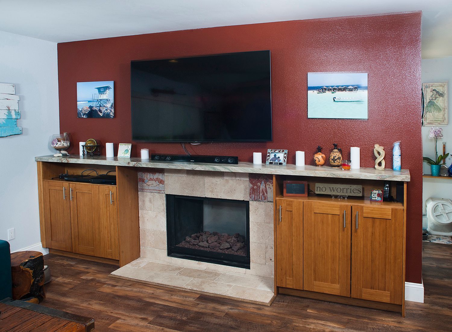 Living room with fireplace and TV on a red wall; cabinets on either side.