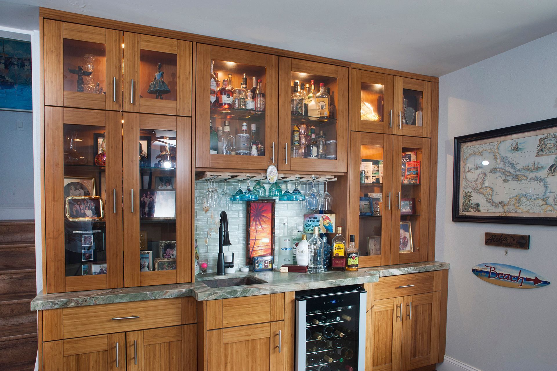 Wooden home bar with glass-front cabinets, a sink, and a wine fridge.