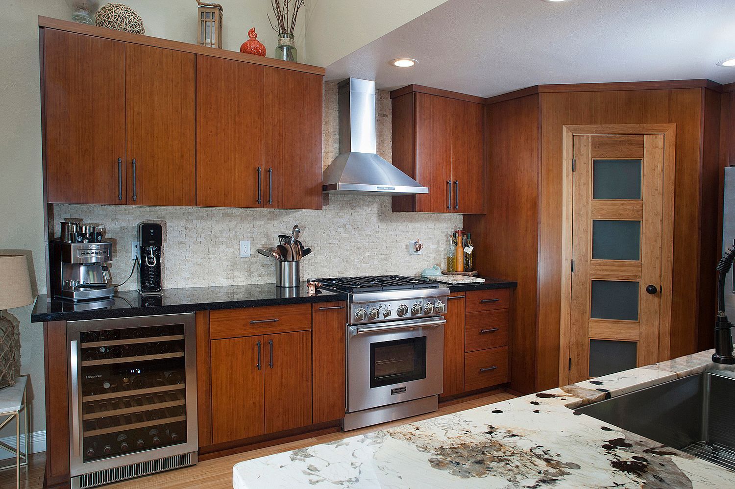 Wooden kitchen with stainless steel appliances and granite countertops.