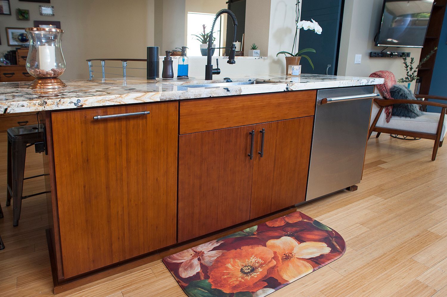 Kitchen island with wooden cabinets, granite countertop, and stainless steel dishwasher.