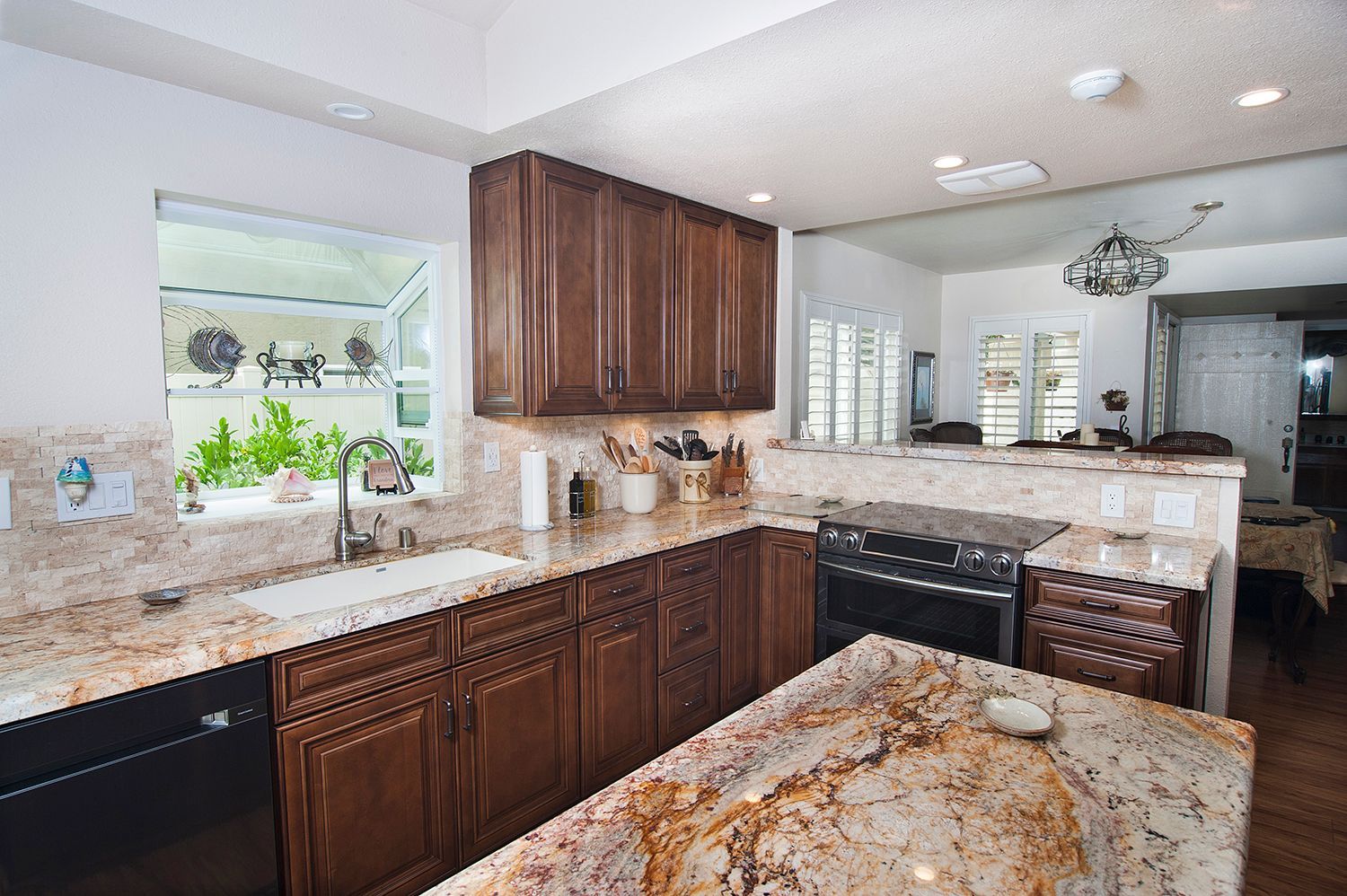 Kitchen with dark brown cabinets, granite countertops, and a breakfast bar.