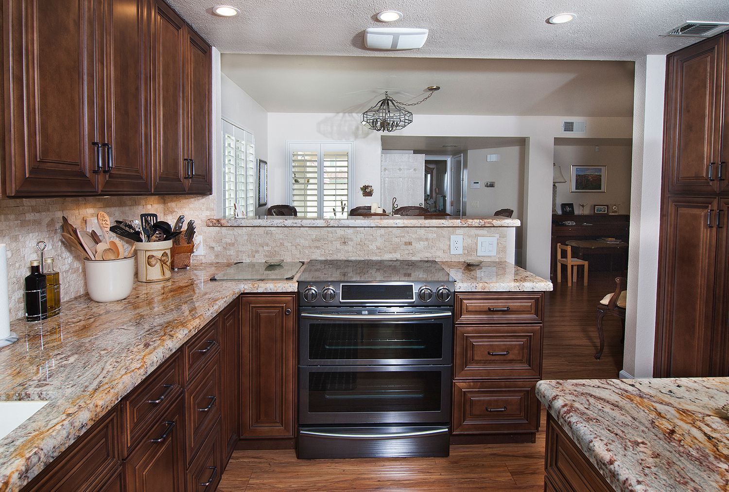 Kitchen with brown cabinets, granite countertops, and a stainless steel oven.