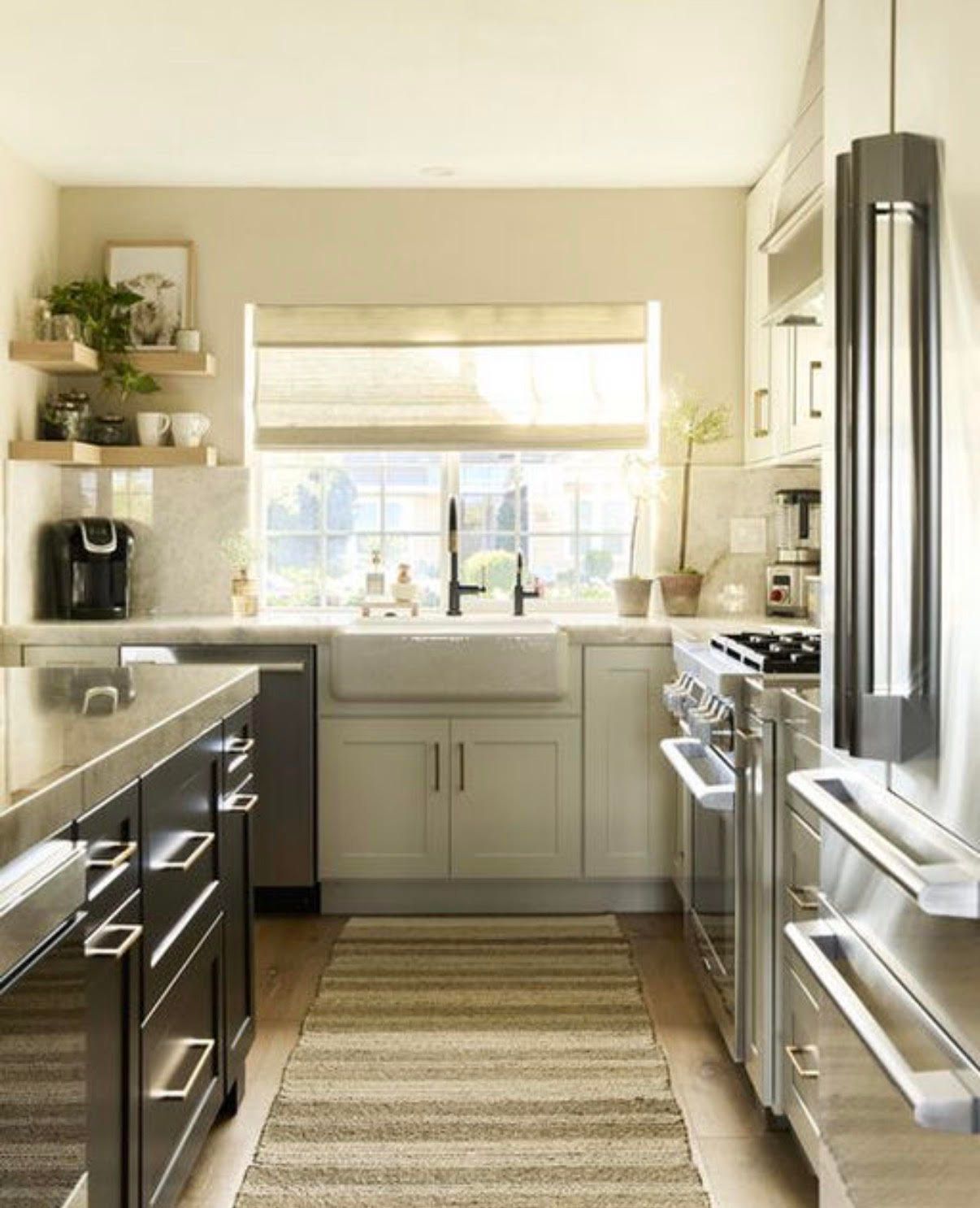 Modern kitchen with stainless steel appliances, light cabinets, and a farmhouse sink.
