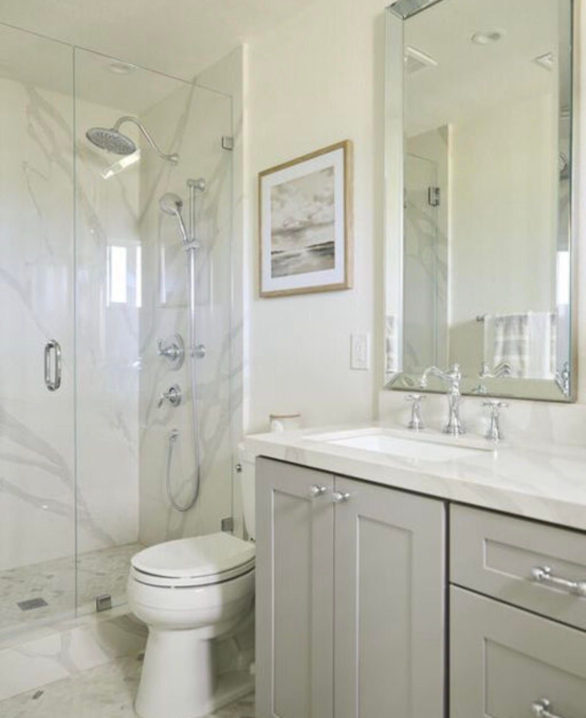 A bathroom with white cabinets , a sink , and a rug.