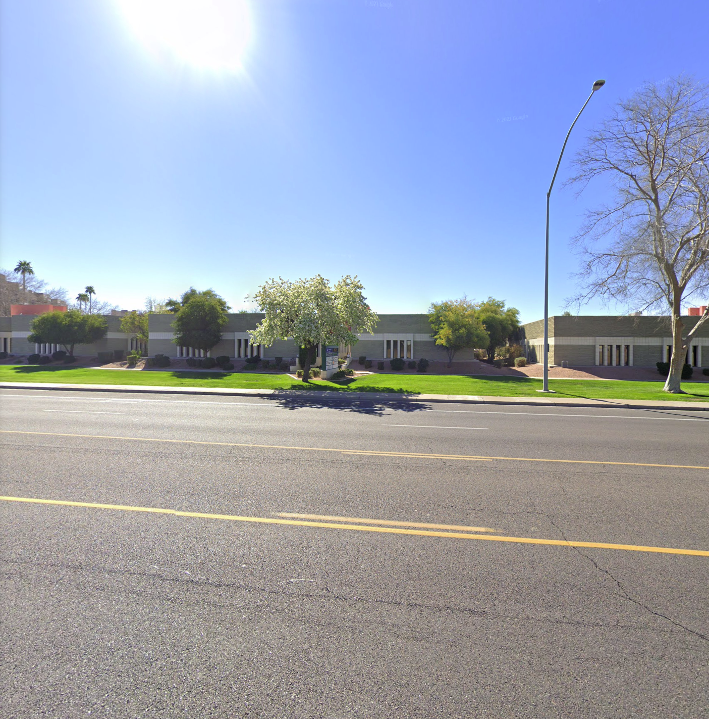 A street with a building in the background and trees on the side