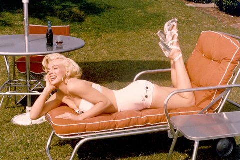 woman is laying on a lounge chair