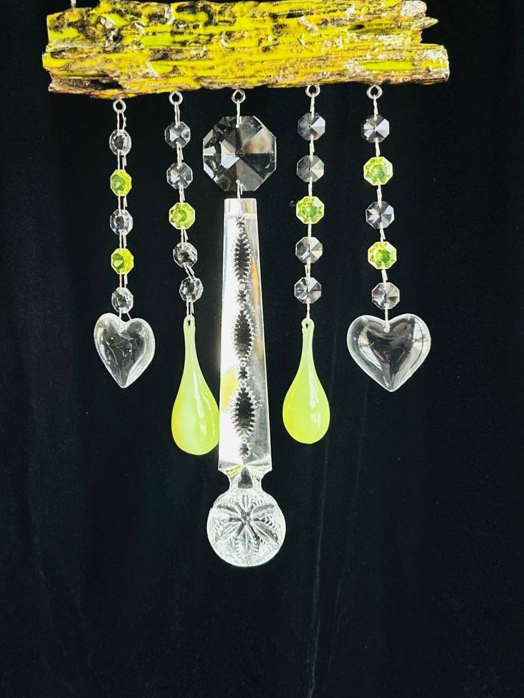 A piece of wood with colored beads hanging from a chain