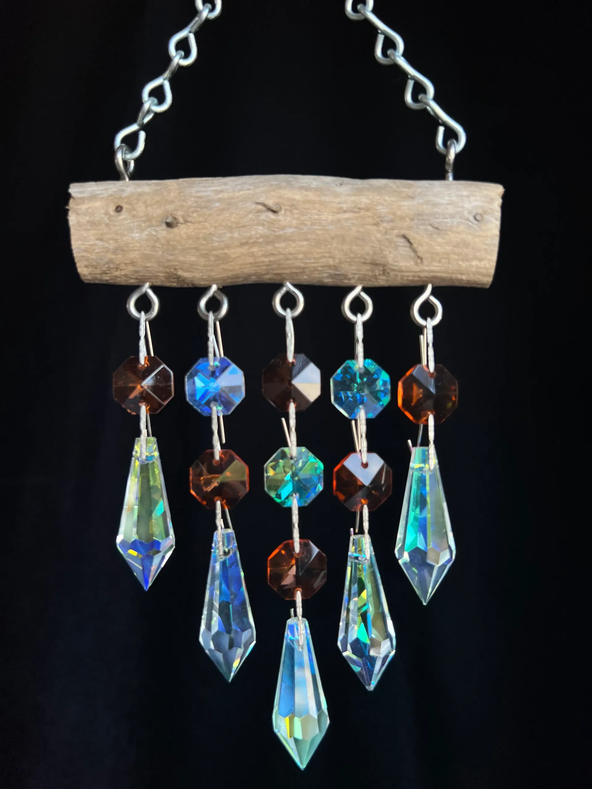 A wind chime made out of a piece of wood and crystals