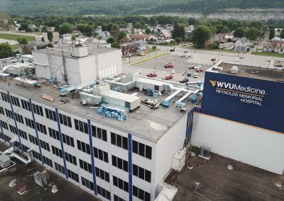 Aerial view of WVU Medicine hospital rooftop and parking lot in a suburban area