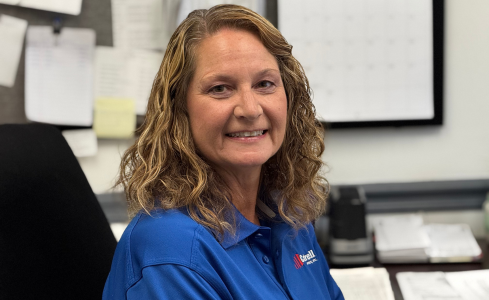 Smiling woman in a blue shirt sitting in an office