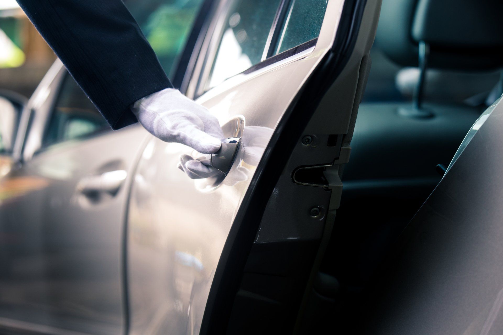 a man in a tuxedo is opening the door of a car