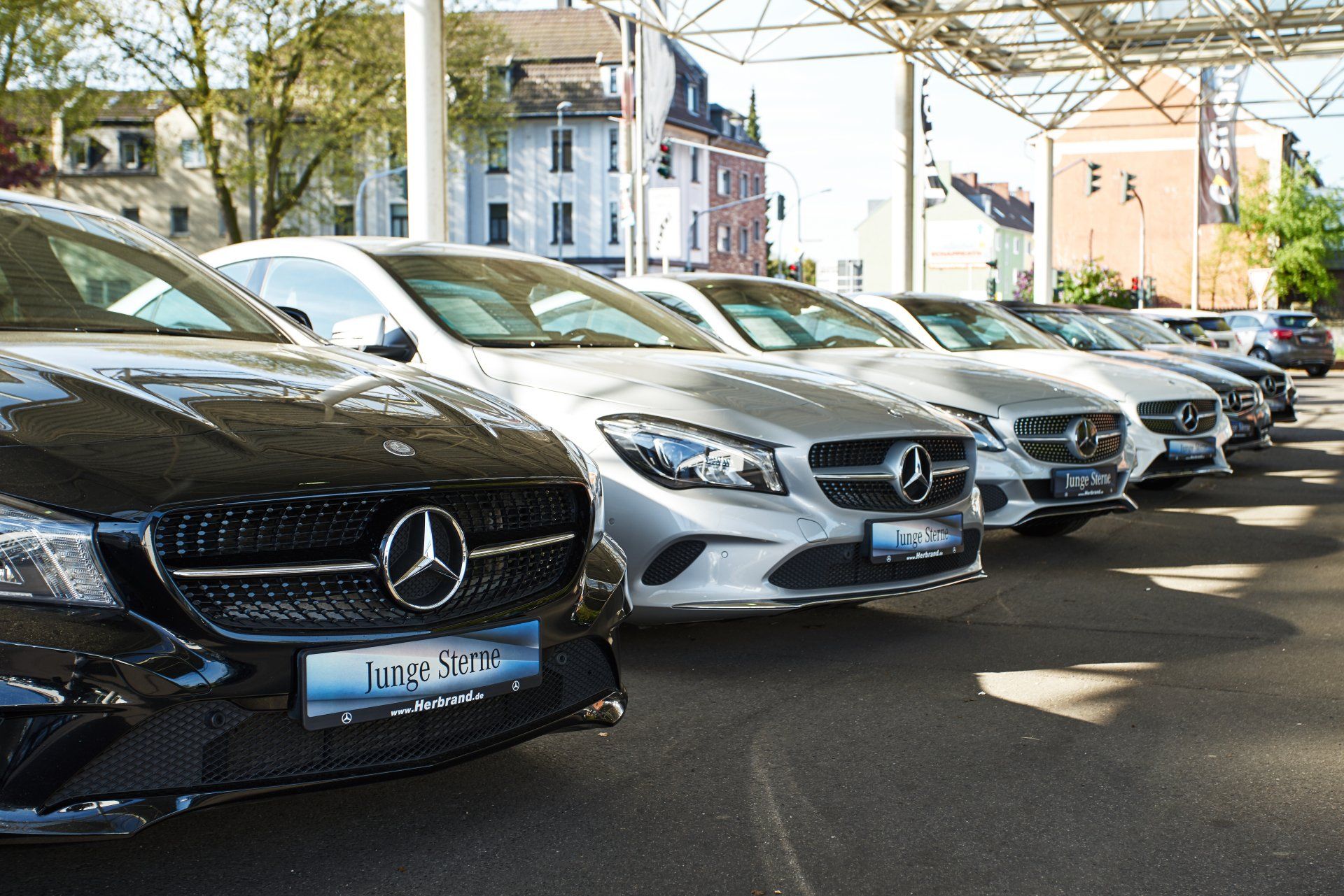 a row of mercedes benz cars are parked in a parking lot