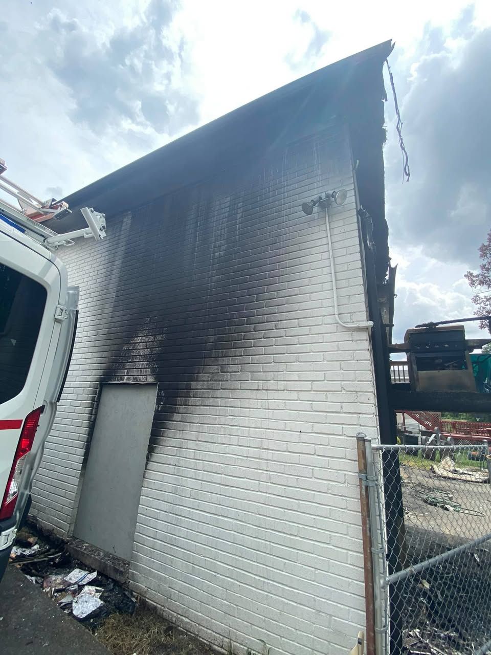 A white brick building with a fire truck parked in front of it.