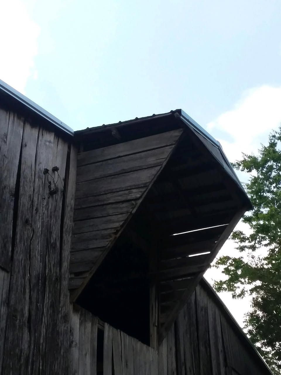 A wooden building with a roof that has a triangle on it