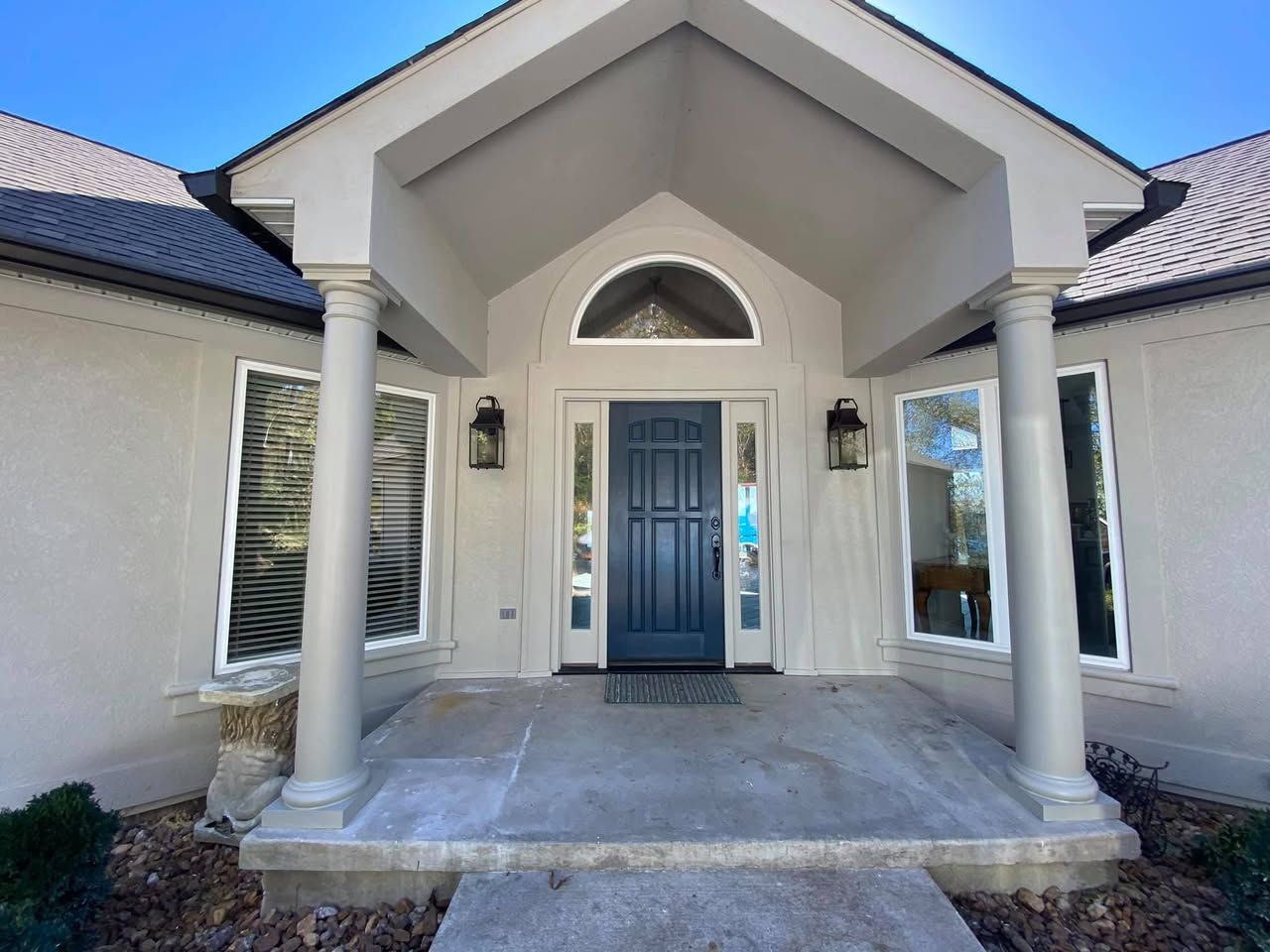 The front of a house with a blue door and columns