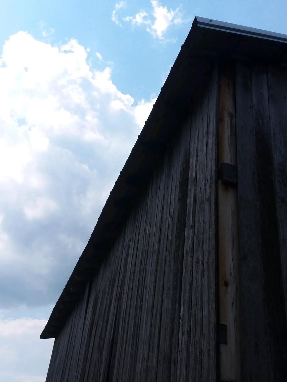 A dark wooden building with a blue sky in the background