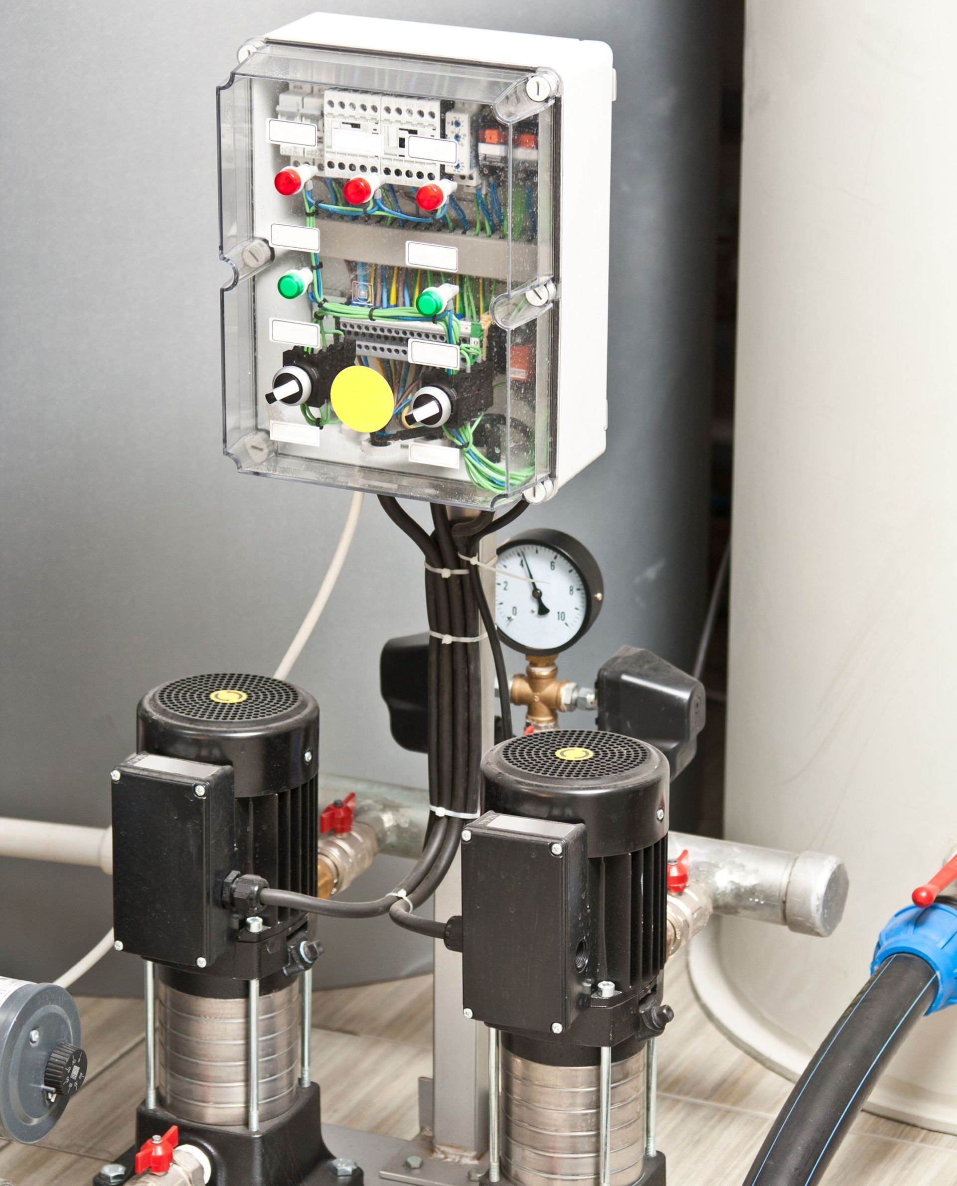 Water pump system with two black motors, control box, and pressure gauge.