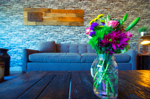 a vase of flowers is sitting on a wooden table in a living room.