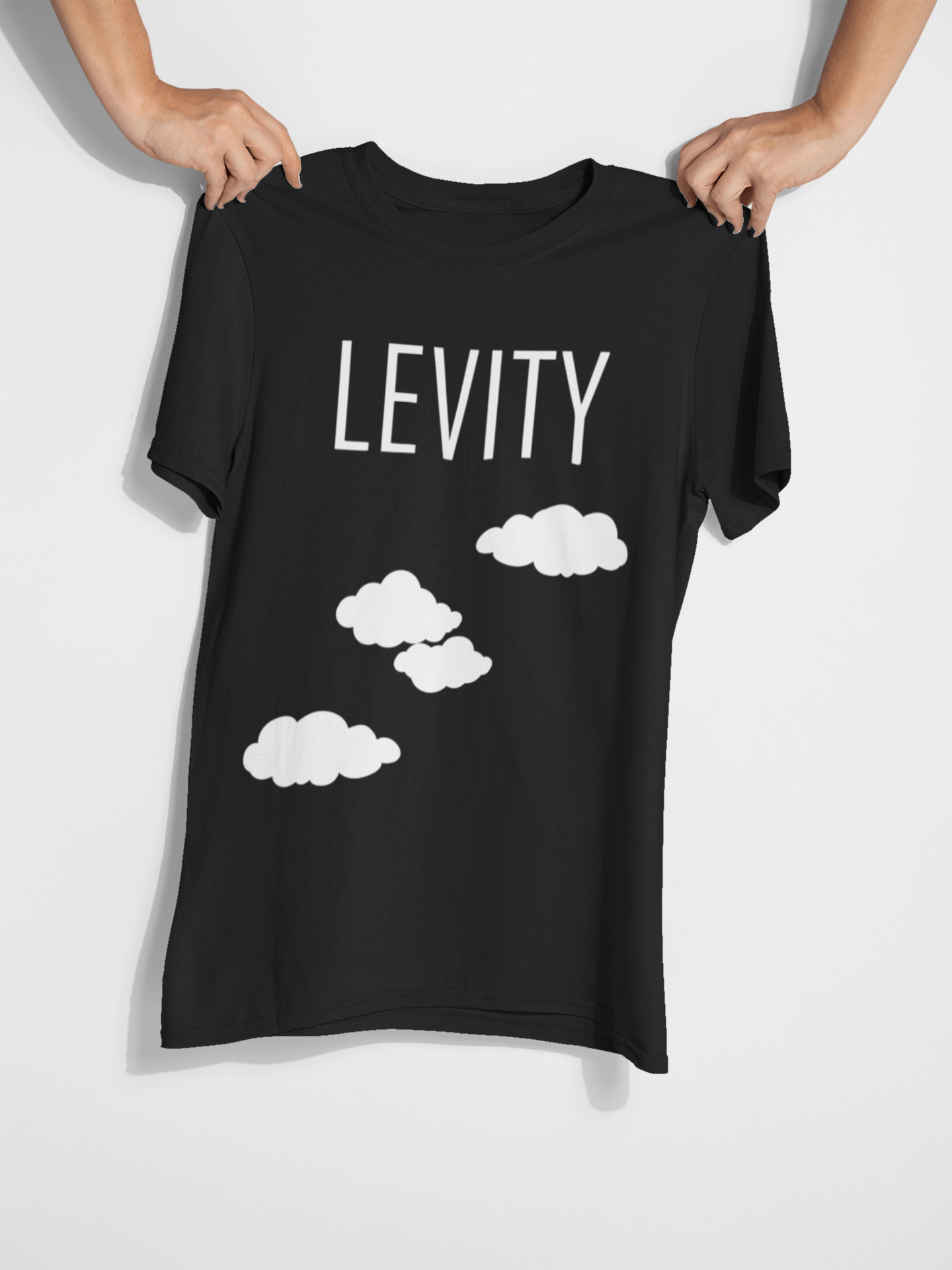 Black shirt being held by two hands, white background, Levity in white lettering and clouds on the shirt.