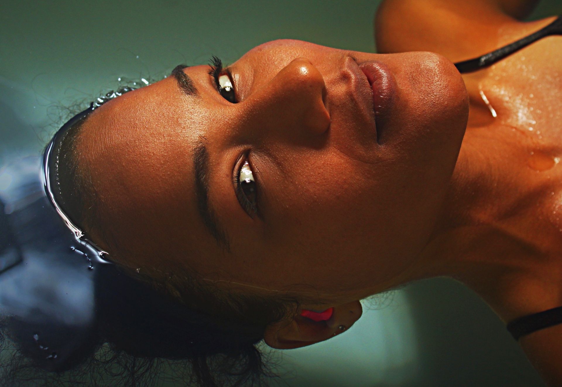 A woman is floating on her back in a bathtub.