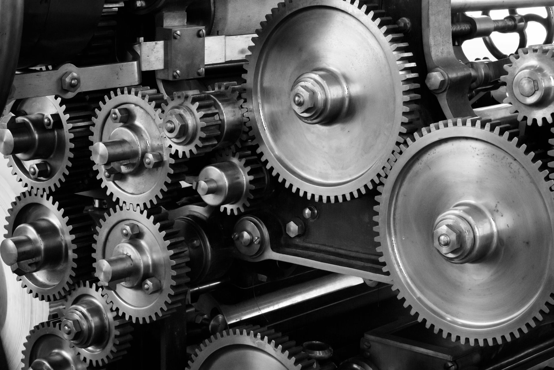 A black and white photo of a machine with lots of gears.