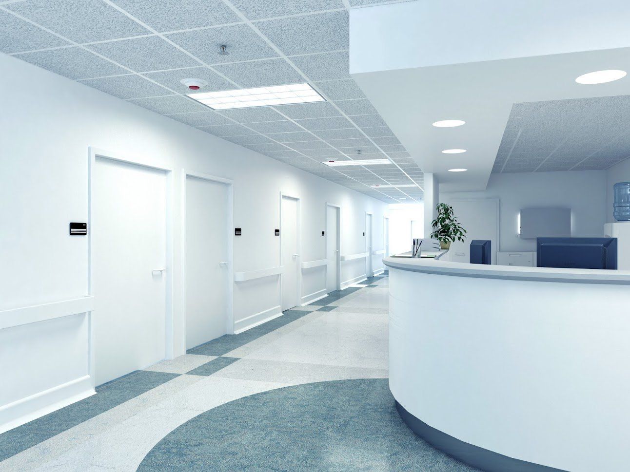 A hospital hallway with a reception desk in the middle