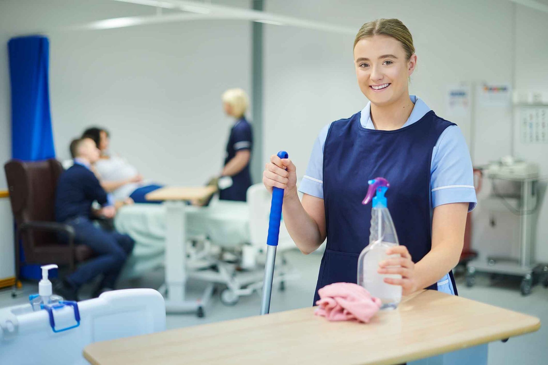 A nurse is cleaning a table in a hospital room.