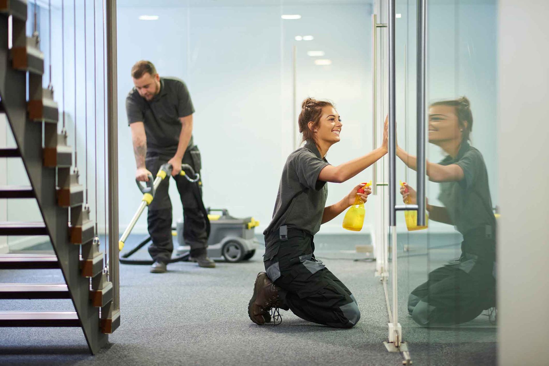 A man and a woman are cleaning a building.