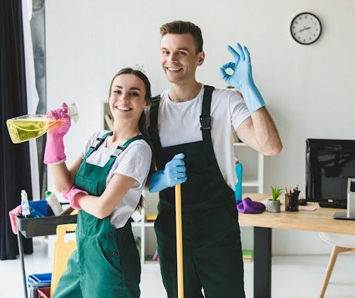 A man and a woman are standing next to each other holding cleaning supplies.