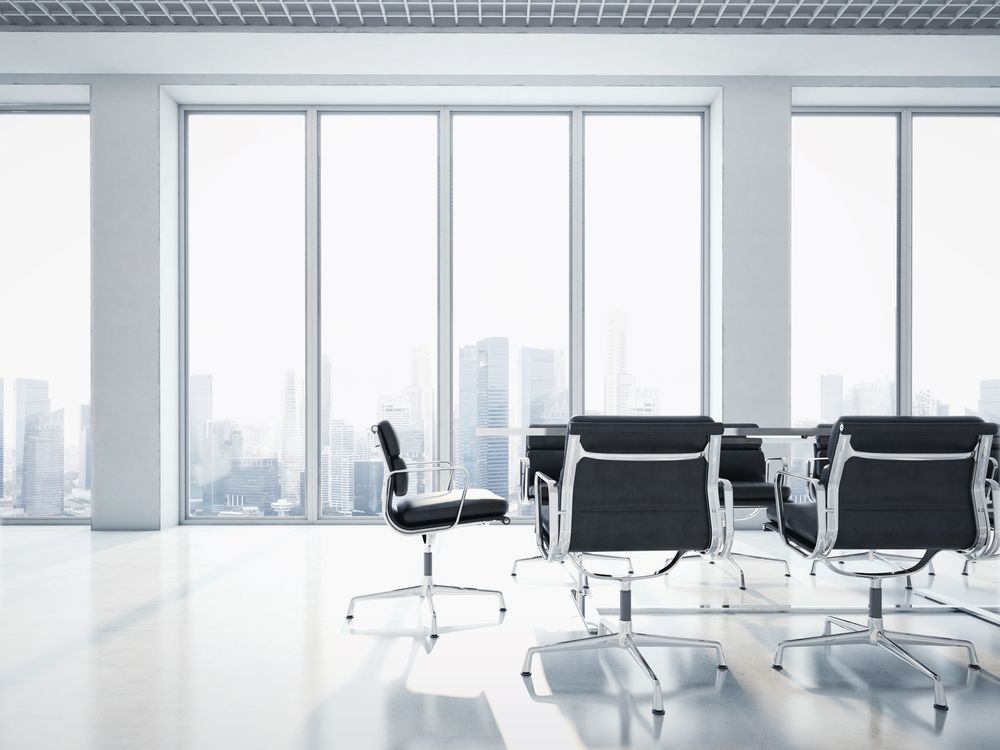 A conference room with a table and chairs and a lot of windows.