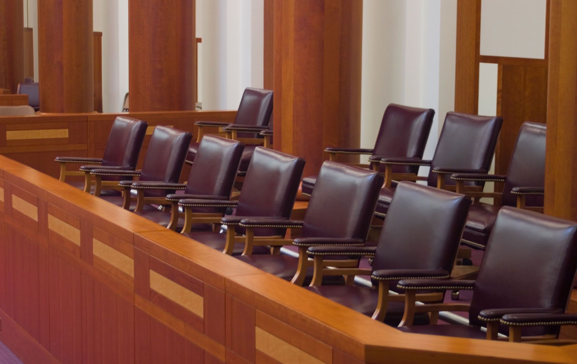 A row of chairs are lined up in a courtroom