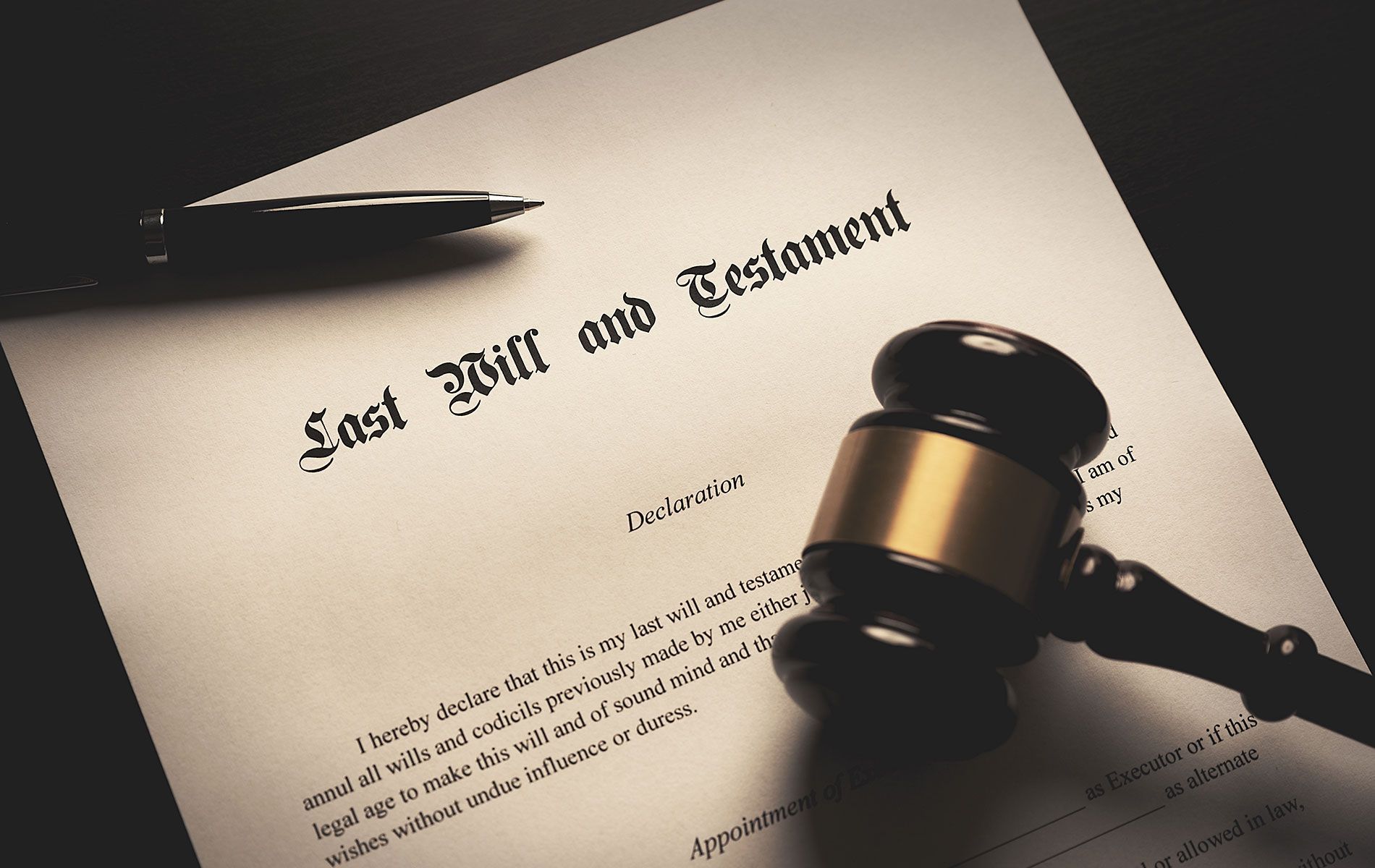 A gavel is sitting on top of a last will and testament